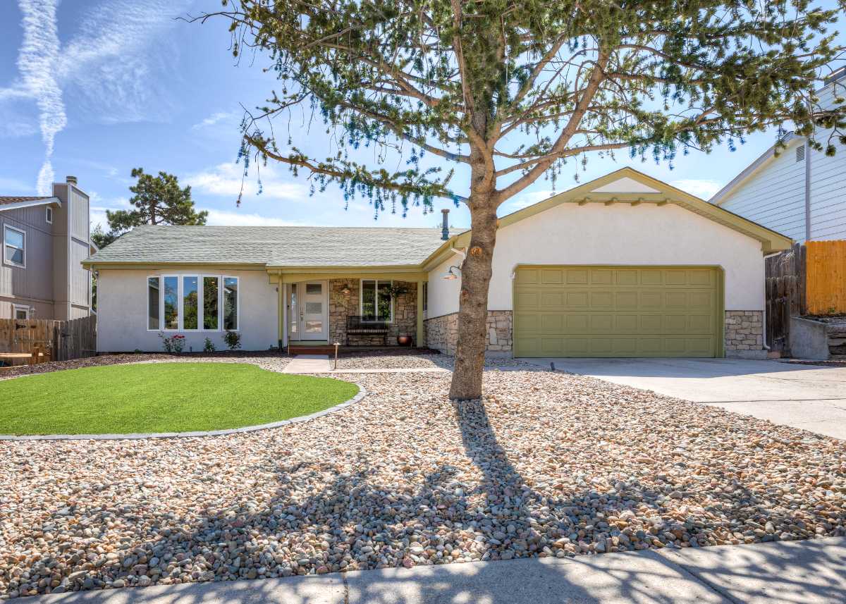 Contemporary hillside home with expansive wooden deck and panoramic city views in Colorado Springs | Top Tier Real Estate