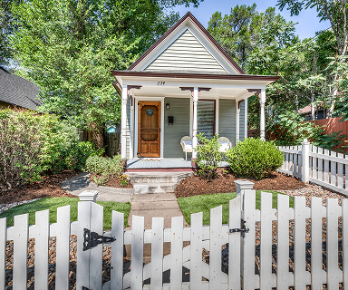 Two-story craftsman home with covered front porch and lush landscaping in a quiet Colorado Springs neighborhood | Top Tier Real Estate